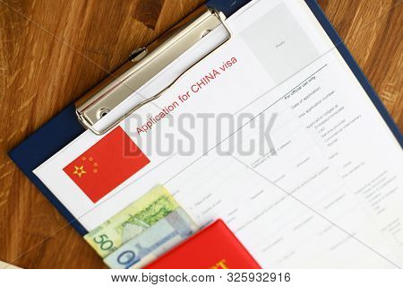 Red Passport Lie Against China Application Form Backgroung Cloceup.