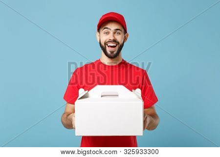 Delivery Man In Red Uniform Isolated On Blue Background, Studio Portrait. Male Employee In Cap T-shi