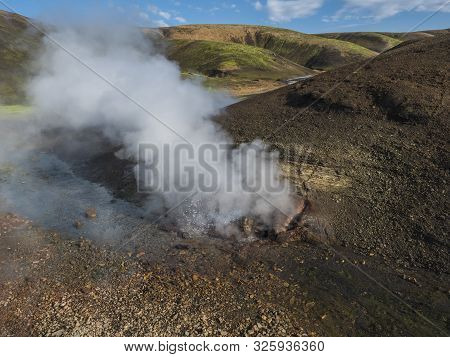Hot Spring With Boiling Water Rising From Rocks In Landmannalaugar Colorful Rhyolit Mountains On Fam