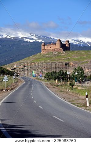 La Calahorra, Spain - May 5, 2010 - Castle With Snow Capped Mountains Of The Sierra Nevada To The Re