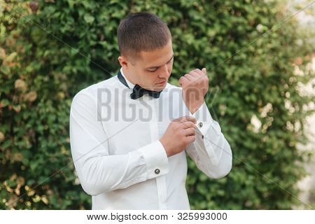 Young Man In White Shirt With Black Tie Bow Stand Outside