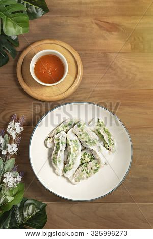 Top View Vietnamese Steamed Rice Dumplings Served With Spicy Chili Sauce Over Wooden Table