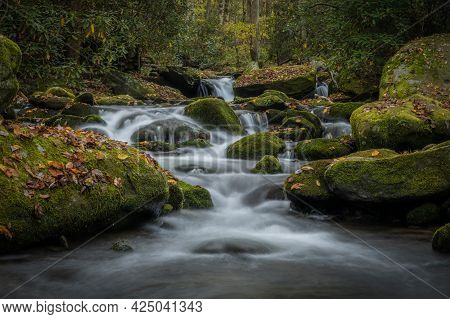 Low Angle Of Water Rushing Around Mossy Boulders In Great Smoky Mountains National Park