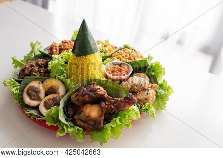 Nasi Tumpeng. Indonesian Cuisine Yellow Rice On Banana Leaf