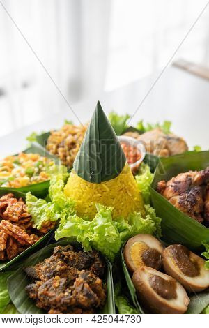 Nasi Tumpeng. Indonesian Cuisine Yellow Rice On Banana Leaf