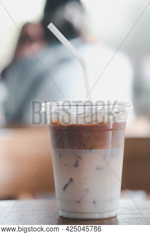 Iced Latte Coffee In A Plastic Glass 16oz. On Wood Table