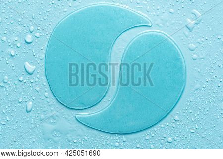 Hydrogel Blue Eye Patches On Blue Background With Water Drops Close Up. Cosmetic Moisturizing Under 