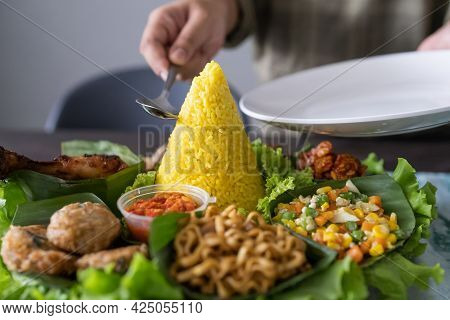 Nasi Tumpeng. Indonesian Cuisine Yellow Rice On Banana Leaf