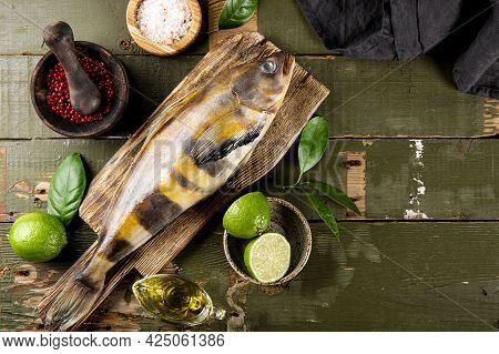 Raw Fish Sea Bass Or Lingcod And Seasonings For Cooking It On An Old Plank Background Top View, Free