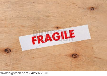 A Paking Tape With Fragile Word On A Wooden Background