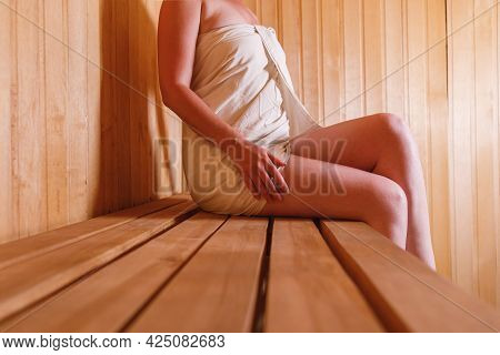Traditional Old Russian Bathhouse Spa Concept. Woman In Towel Relaxing In Traditional Finnish Sauna