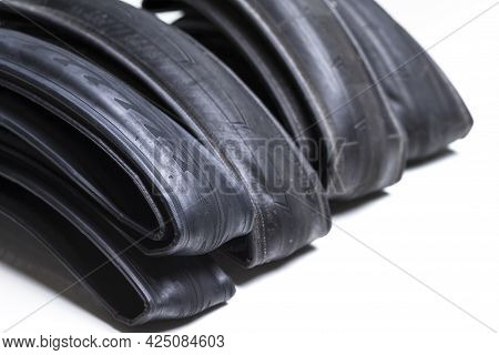 Closeup Image Of Set Of Four Different Road Bike Folded Tyres Placed Together Over White Background.