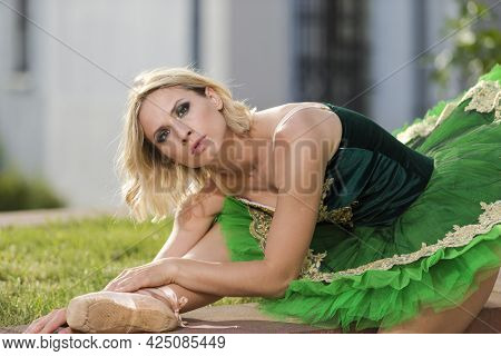 Dancing Concepts. Portrait Of Professional Caucasian Ballet Dancer In Green Tutu Dress Making Up Her