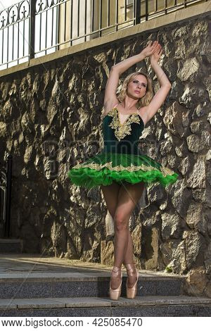 Dancing Concepts. Portrait Of Professional Caucasian Ballet Dancer In Green Tutu Dress Making Up Her