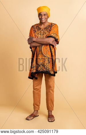 Mixed senior Indian man wearing a yellow turban and a dashiki