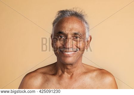 Happy bare chested mixed Indian senior man