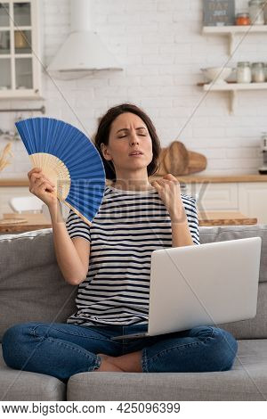 Tired Millennial Woman Suffers From Stuffiness And An Inoperative Air Conditioner, Waving Blue Fan S