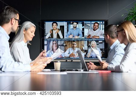 Global Corporation Online Videoconference In Meeting Room With Diverse People Sitting In Modern Offi