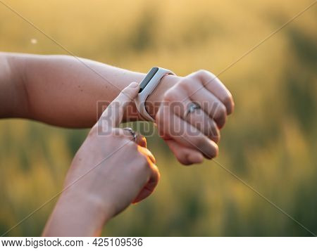 Woman using fittness watch to measure workout. Analyze helath data using smart watch.