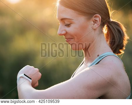 Woman using fittness watch to measure workout. Analyze helath data using smart watch.