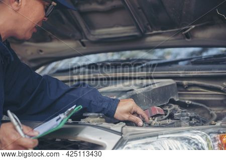 Car Mechanic Man Hand Checking Dipstick Engine Oil Car Mechanical On Site Service. Close Up Hand Man