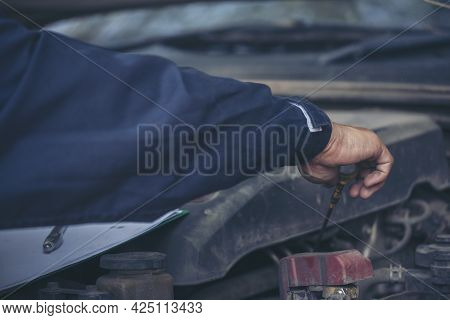 Car Mechanic Man Hand Checking Dipstick Engine Oil Car Mechanical On Site Service. Close Up Hand Man
