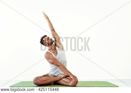 Male Yoga Maditates In Classical Pose In Studio Over White Background