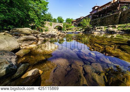 Mountain Stream With Crystal Clear Water Passing Next To A Town. Barcena Mayor Santander.