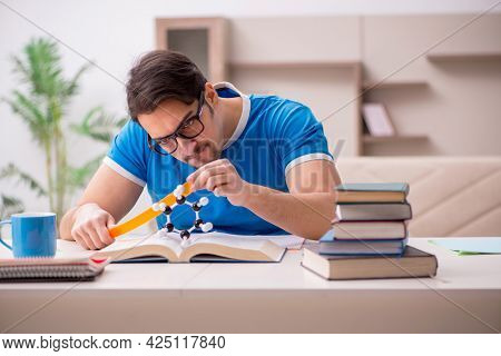 Young male student physicist studying molecular model