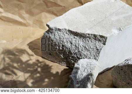 Creative Grey Stone Podium For Cosmetics Or Products On Craft Paper Background. Modern Presentation 