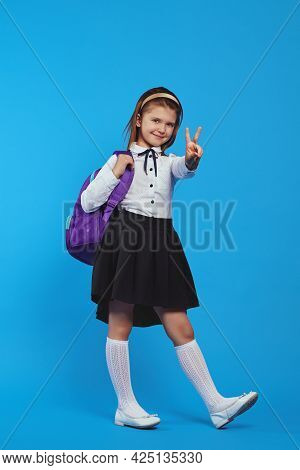 Vertical Shot Of Full Body Girl Wearing Backpack And Showing Peace Gesture
