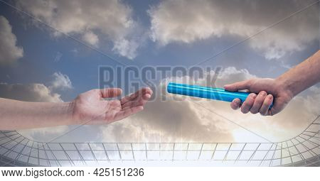 Composition of male runner passing baton to his teammate at stadium. sport and competition concept digitally generated image.