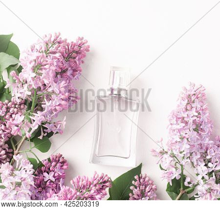 A Bottle Of Perfume And Lilac On A White Background . Womens Perfume. Spring Fragrance. Aromatherapy