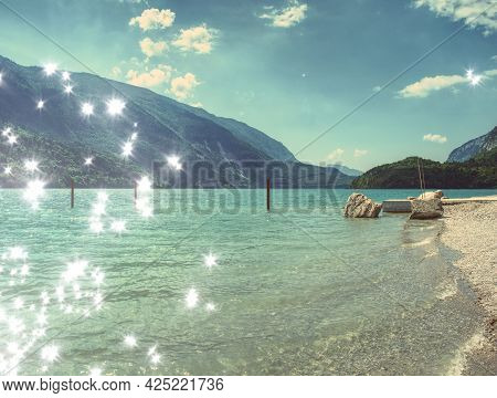 Jet Pier And Pebbles Beach At Bblue Alpine Lake. Warm Sunrays Over Hills.  Abstract.