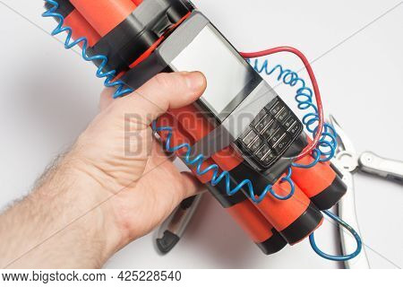 A Man Is Holding A Bomb With A Timer Made From A Smartphone. Survival And Terrorism Concept. White B