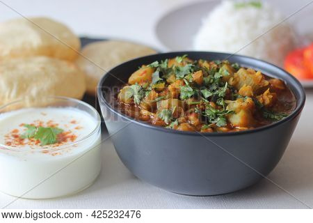 Bottle Gourd Curry With Lentils Served With Steamed Basmati Rice And Deep Fried Whole Wheat Indian F