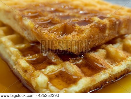 Freshly Baked Waffles In Syrup For Breakfast. Closeup.