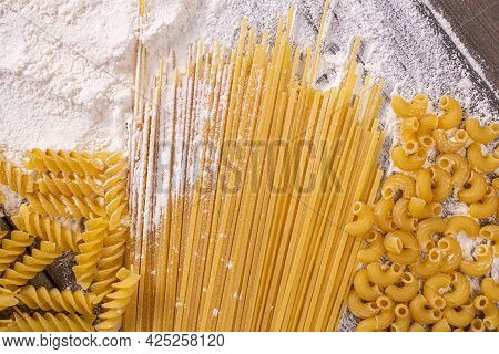 Top View Of The Italian Wheat Pasta Of Three Different Types On The Table With Flour.traditional Rec