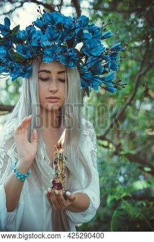 Beautiful Girl In Wreath Of Flowers In Forest. Portrait Of Young Beautiful Woman Wearing White Bride