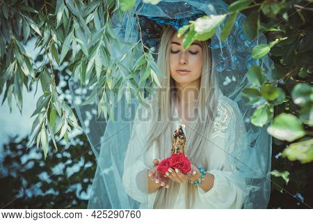 Beautiful Girl In Wreath Of Flowers In Forest. Portrait Of Young Beautiful Woman Wearing White Bride