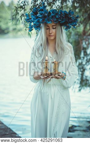 Beautiful Girl In Wreath Of Flowers In Forest. Portrait Of Young Beautiful Woman Wearing White Bride