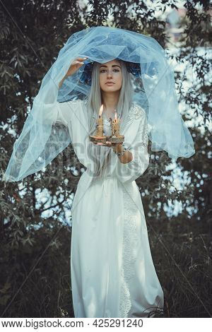 Beautiful Girl In Wreath Of Flowers In Forest. Portrait Of Young Beautiful Woman Wearing White Bride