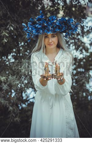 Beautiful Girl In Wreath Of Flowers In Forest. Portrait Of Young Beautiful Woman Wearing White Bride