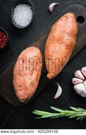 Sweet Potato Or Batat With Herbs And Spices On Black Background, Top View.
