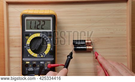 Budapest, Hungary - Circa 2021: Testing AA battery cells from Duracell with digital multimeter tool, voltage check showing low value, battery is used and discharged