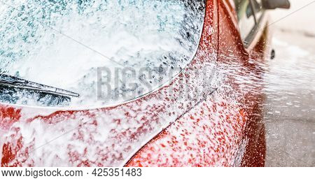 Detail On Car Rear Window Covered With Soap Foam, More Spraying From Brush, When Washed In Carwash