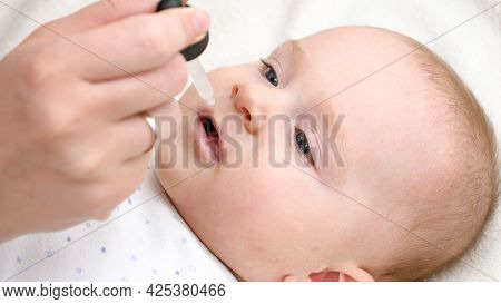 Closeup Of Little Baby Boy Taking Vitamin D From Eyedropper. Concept Of Newborn Healthcare And Vacci