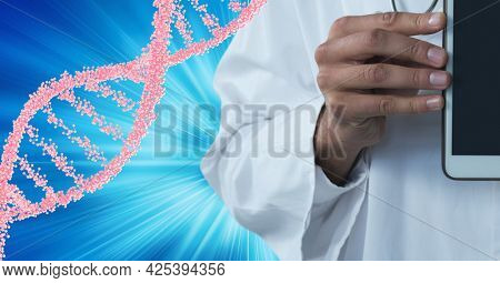 Mid section of male doctor holding a digital tablet against dna structure on blue background. medical research and science technology concept