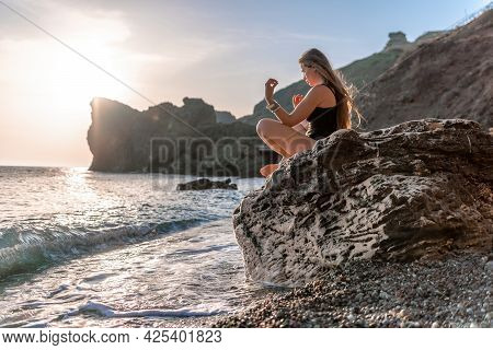Young Woman With Long Hair In Black Swimsuit And Boho Style Braclets Practicing Outdoors On Yoga Mat