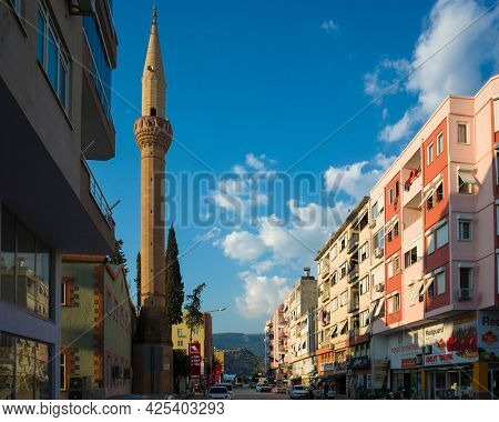 Demre, Turkey - 21 October, 2019: Mosque minaret, residential buildings and street in Demre town, Turkish city view